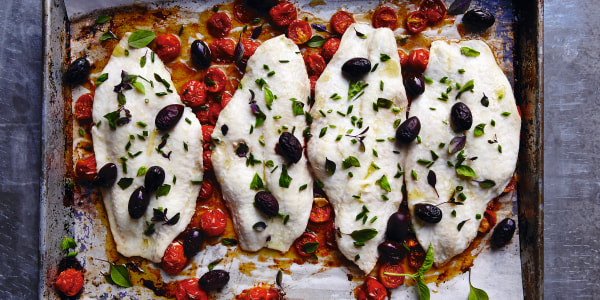 Flounder on plate with roasted tomatoes and black olives